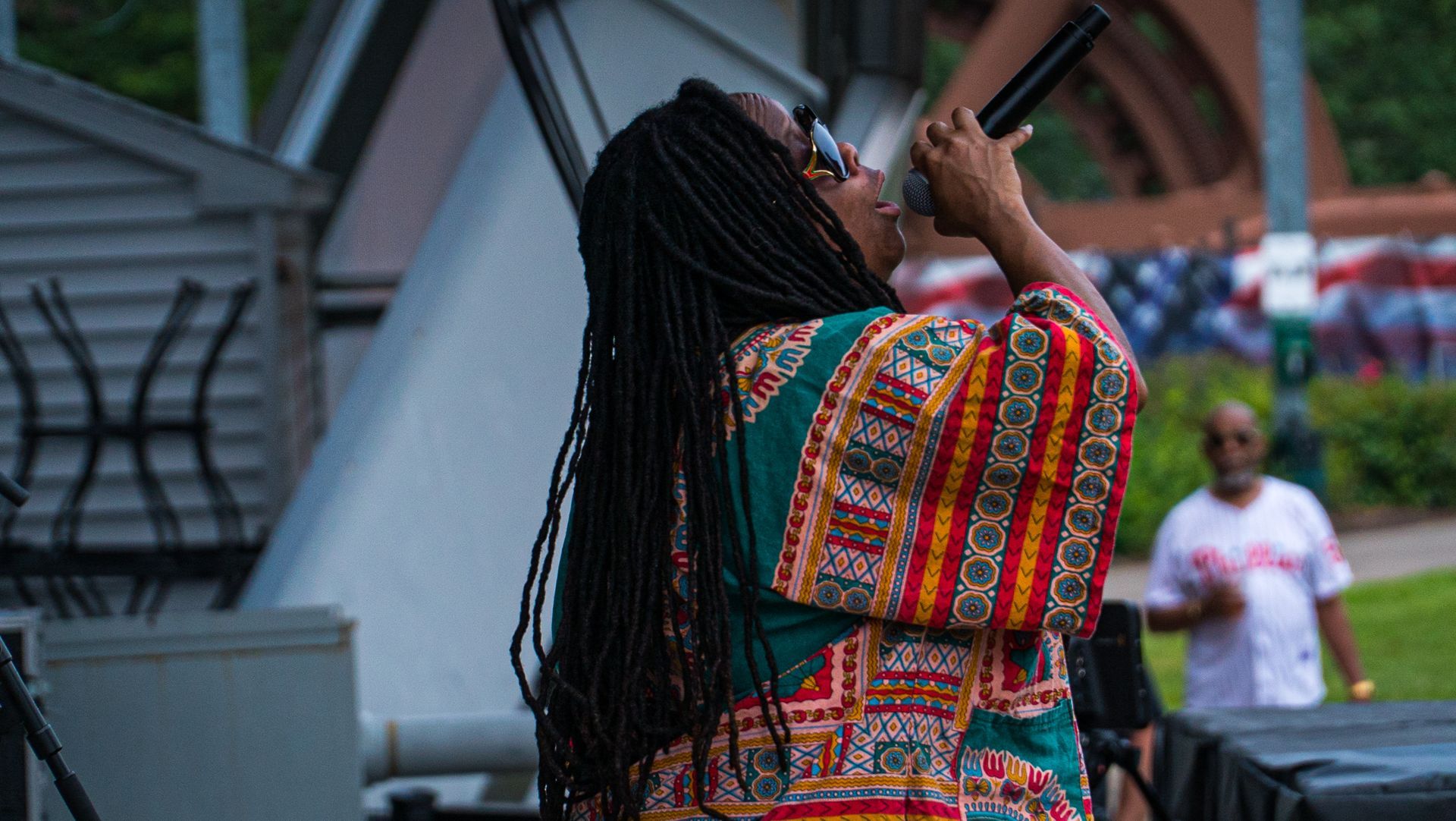 A woman is singing into a microphone on a stage.