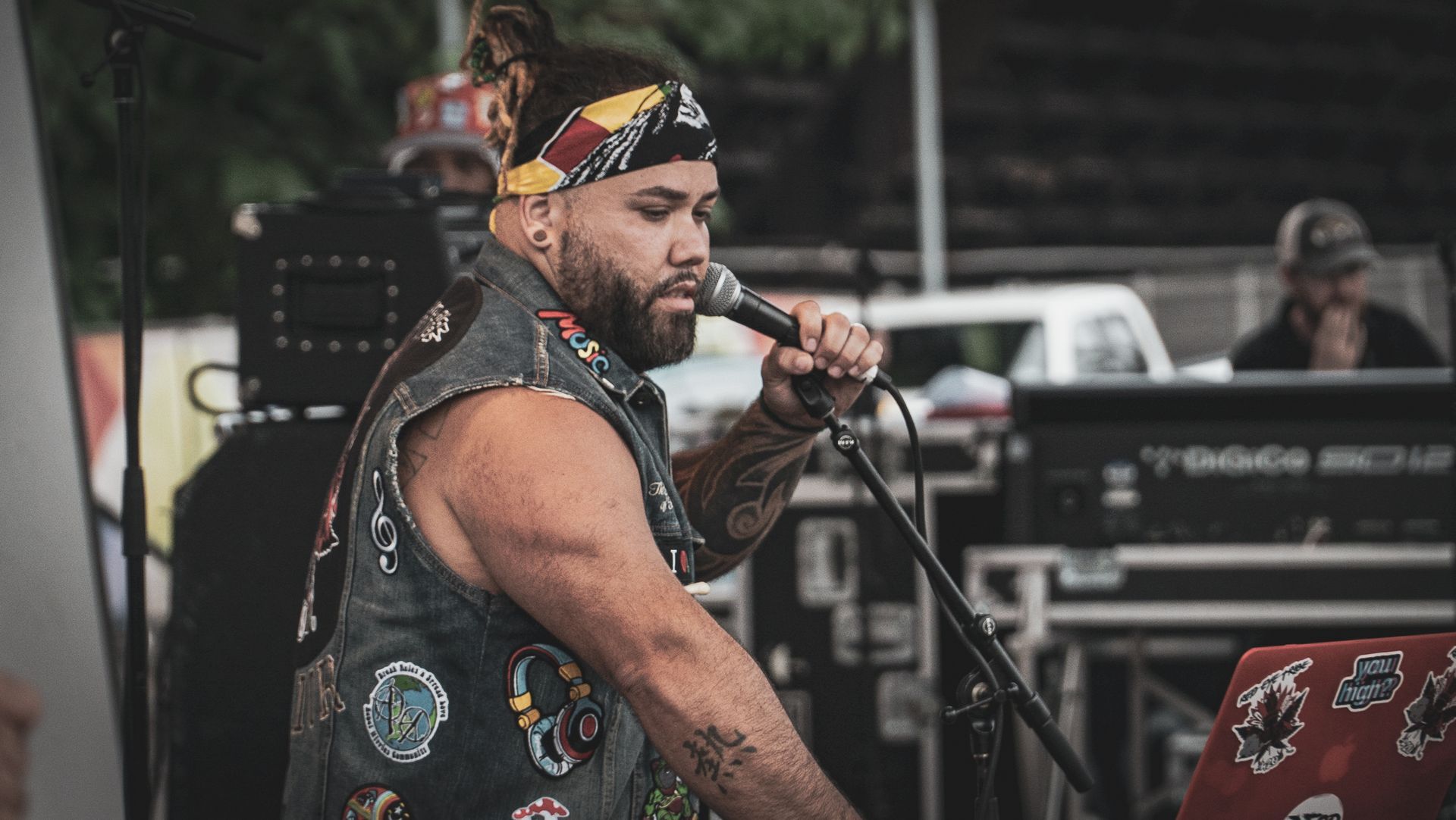 A man is singing into a microphone while playing a keyboard.