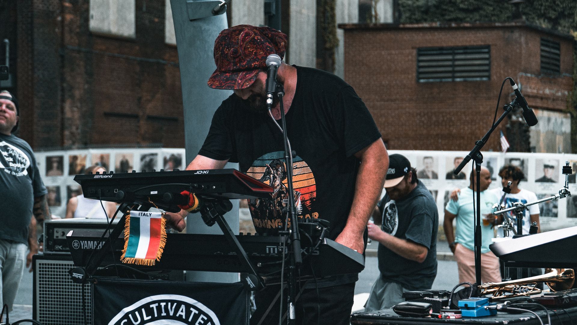 A man is playing a keyboard and singing into a microphone on a stage.