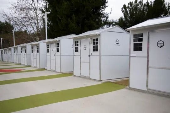 A row of white sheds are lined up in a row.