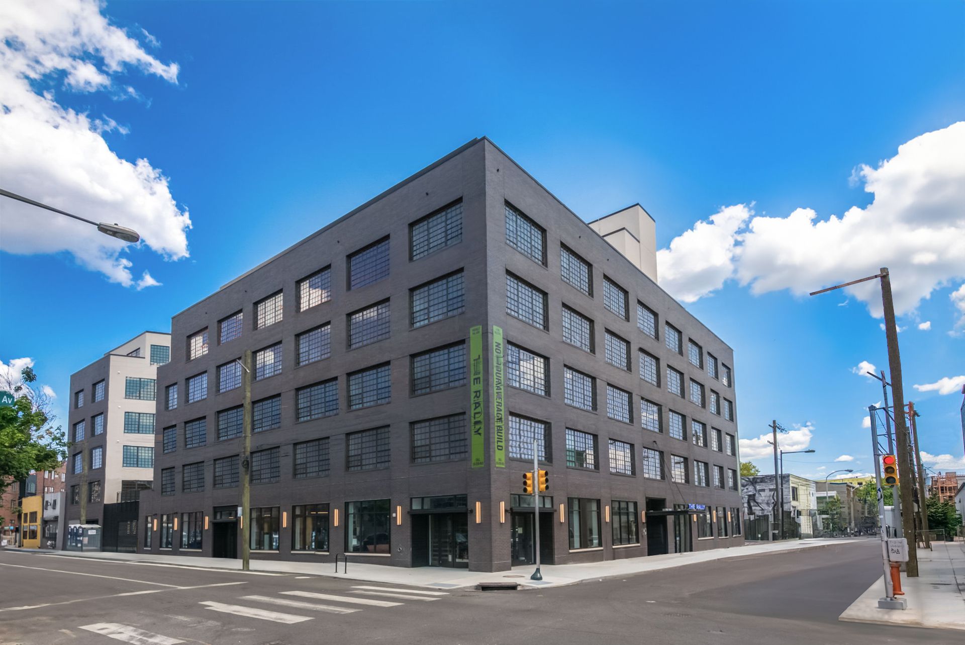 Photo of a large multi-story building at the corner of a city block seen from across the street
