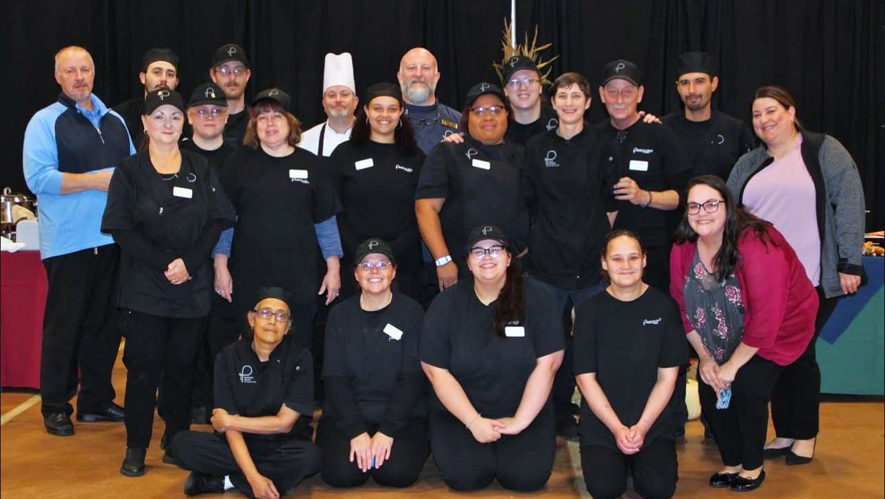 A large group of people are posing for a picture in a room.