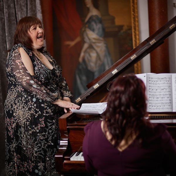 Olga Morozova sat at a wooden piano wearing a purple dress