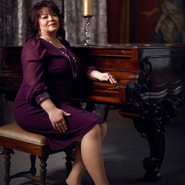 Olga Morozova playing piano for a female singer