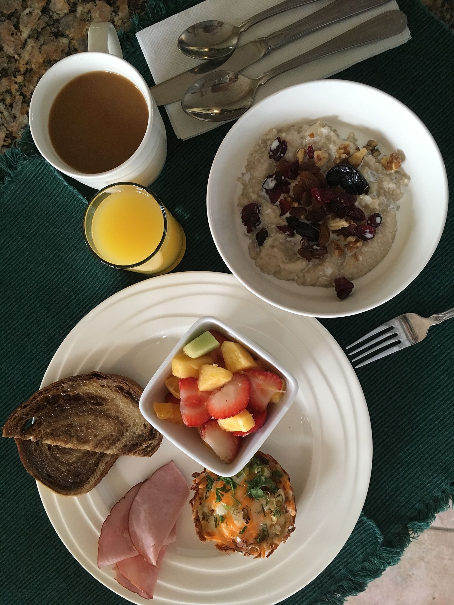 A plate of food with a cup of coffee and a bowl of oatmeal