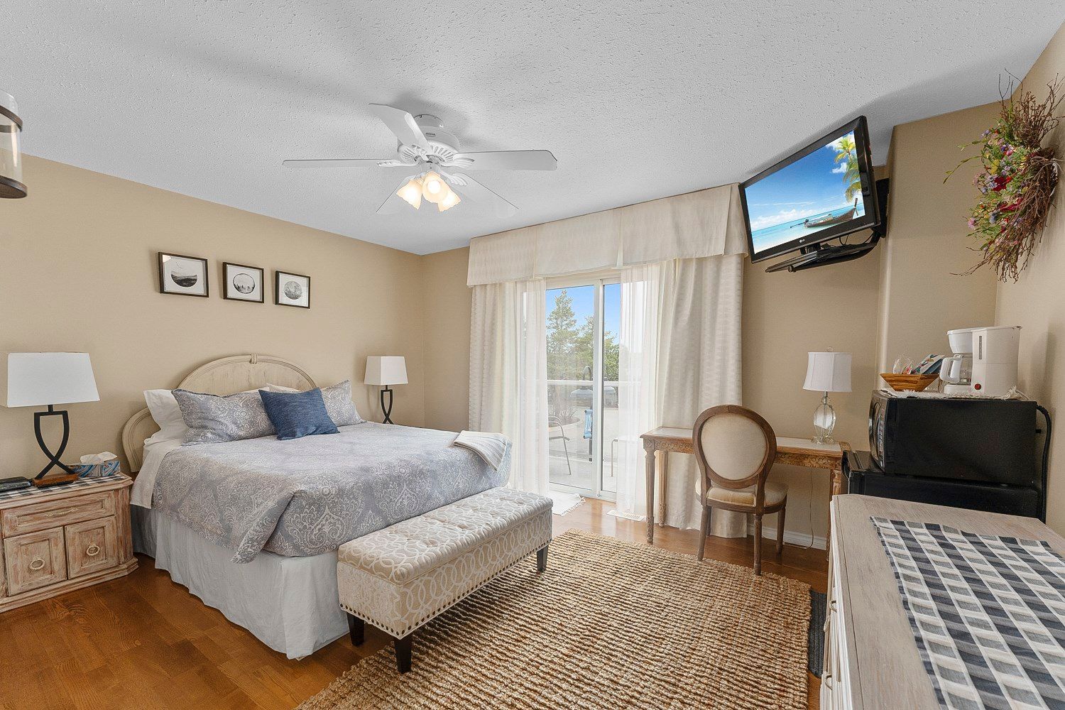 A bedroom with a queen sized bed , desk , chair and television. Lakeshore Inn Bed & Breakfast