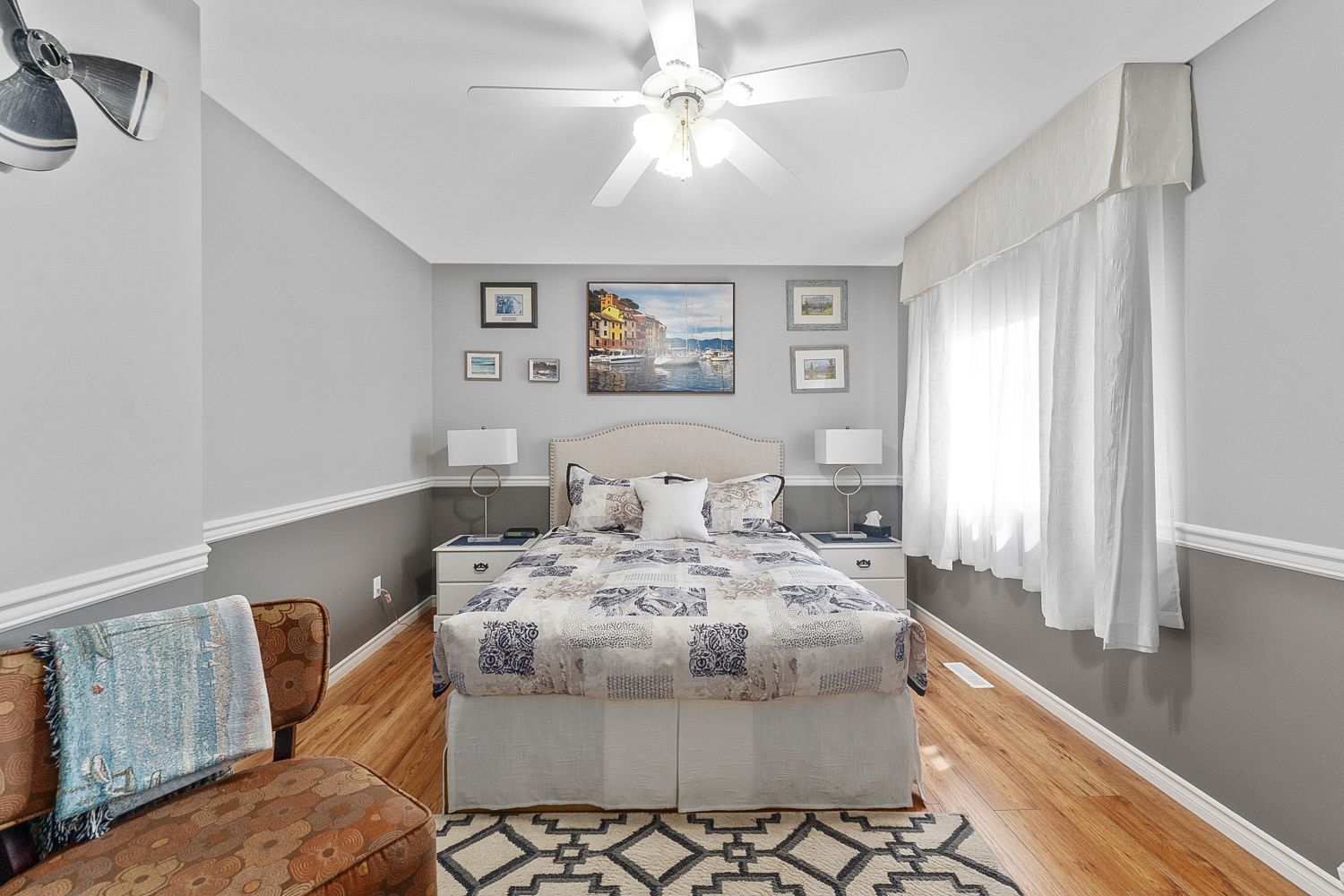 A bedroom with a queen bed , couch, and ceiling fan. Lakeshore Inn Bed & Breakfast