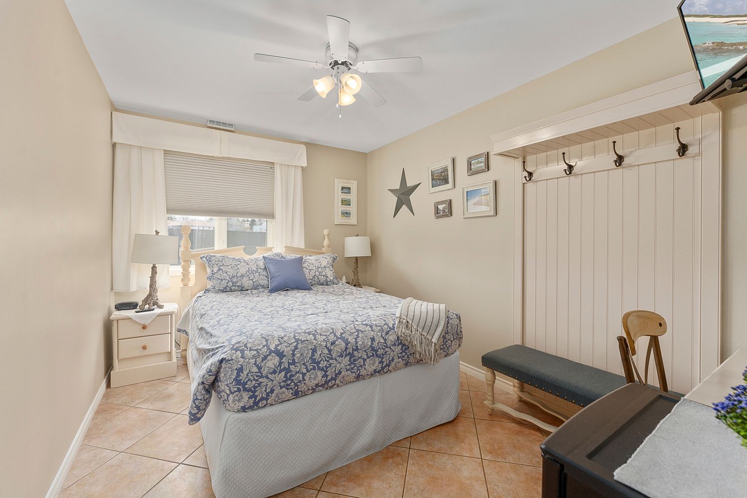 A bedroom with a queen size bed and a ceiling fan. Lakeshore Inn Bed & Breakfast