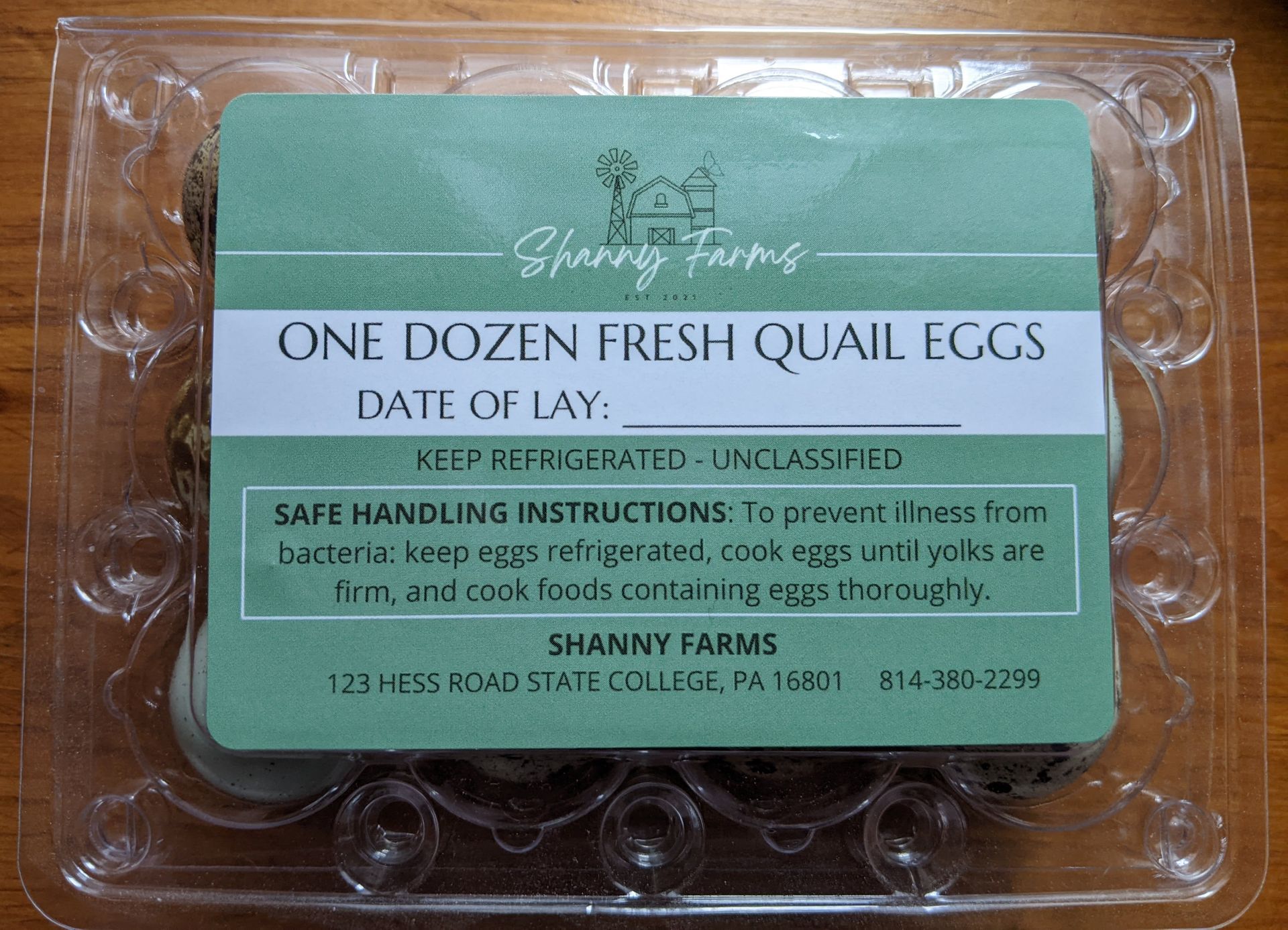 A plastic container of quail eggs with a label on it.