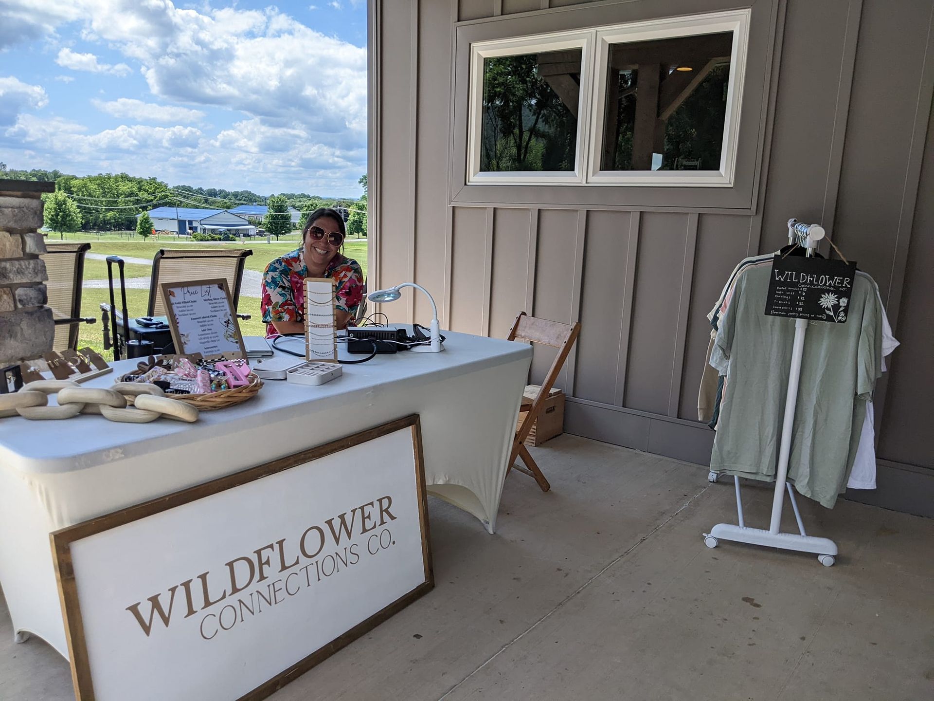 A woman is sitting at a table in front of a building.