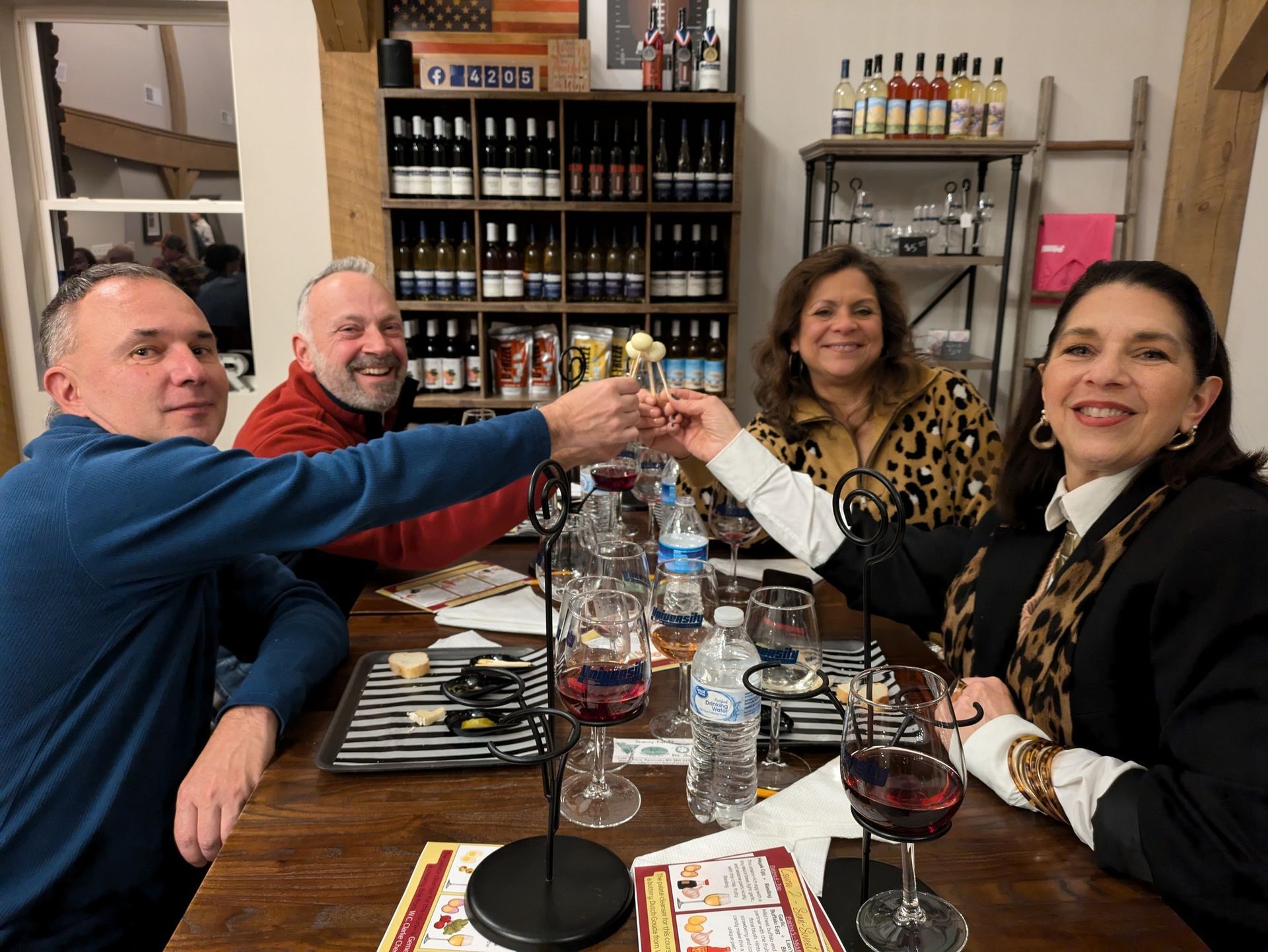 A group of people are sitting at a table toasting a small egg.