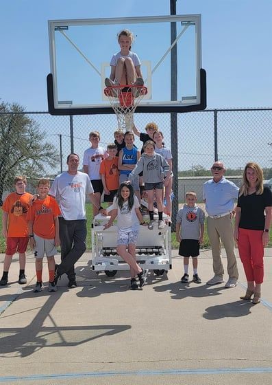 A group of people standing in front of a basketball hoop