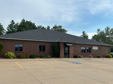 A large brick building with a handicapped parking spot in front of it.