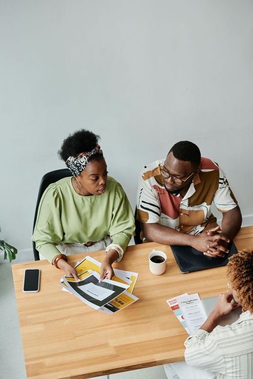 A group of people are sitting at a table having a meeting.