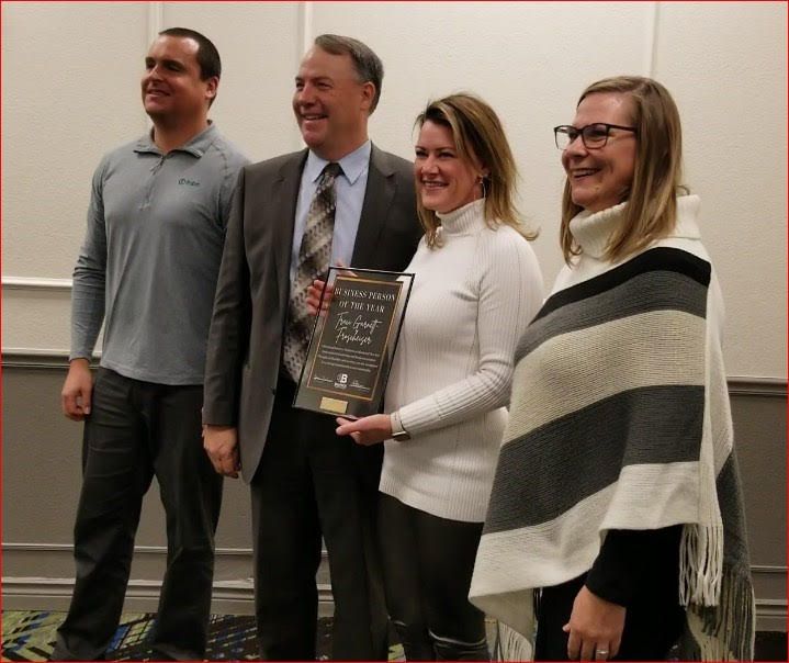 A group of people standing next to each other holding a plaque