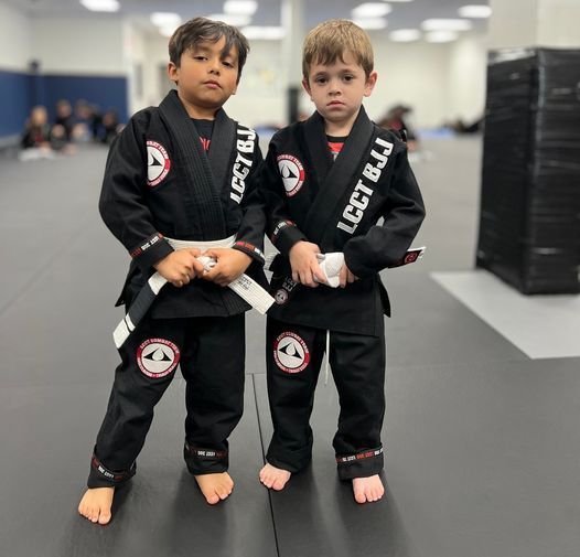 Two young boys wearing black karate uniforms with lcct bjj written on them