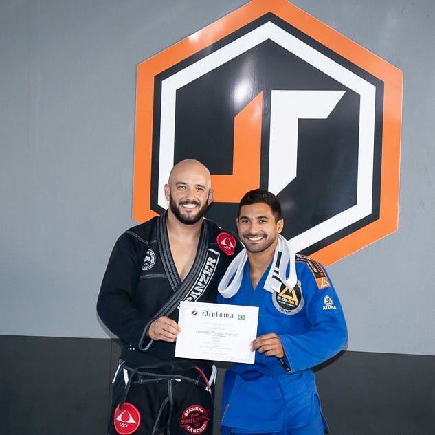 Two men are posing for a picture in front of a sign that says lg