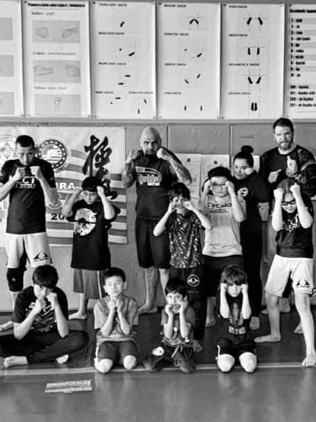 A man is hugging a little boy on a blue mat
