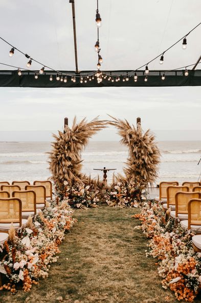 A wedding ceremony is taking place in front of the ocean.