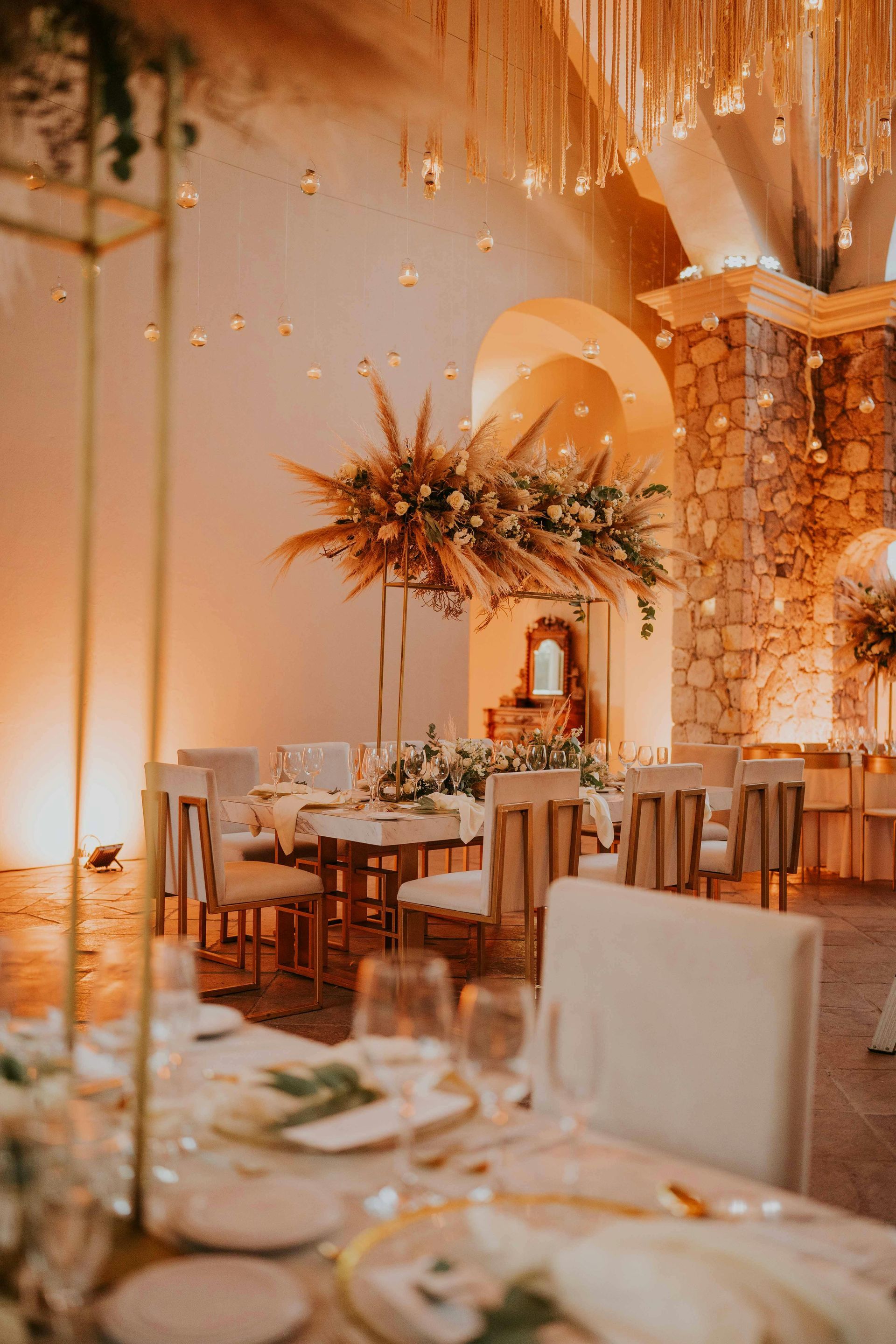 A room with tables and chairs set up for a wedding reception.