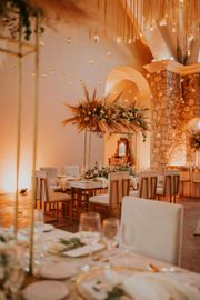 A room with tables and chairs set up for a wedding reception.