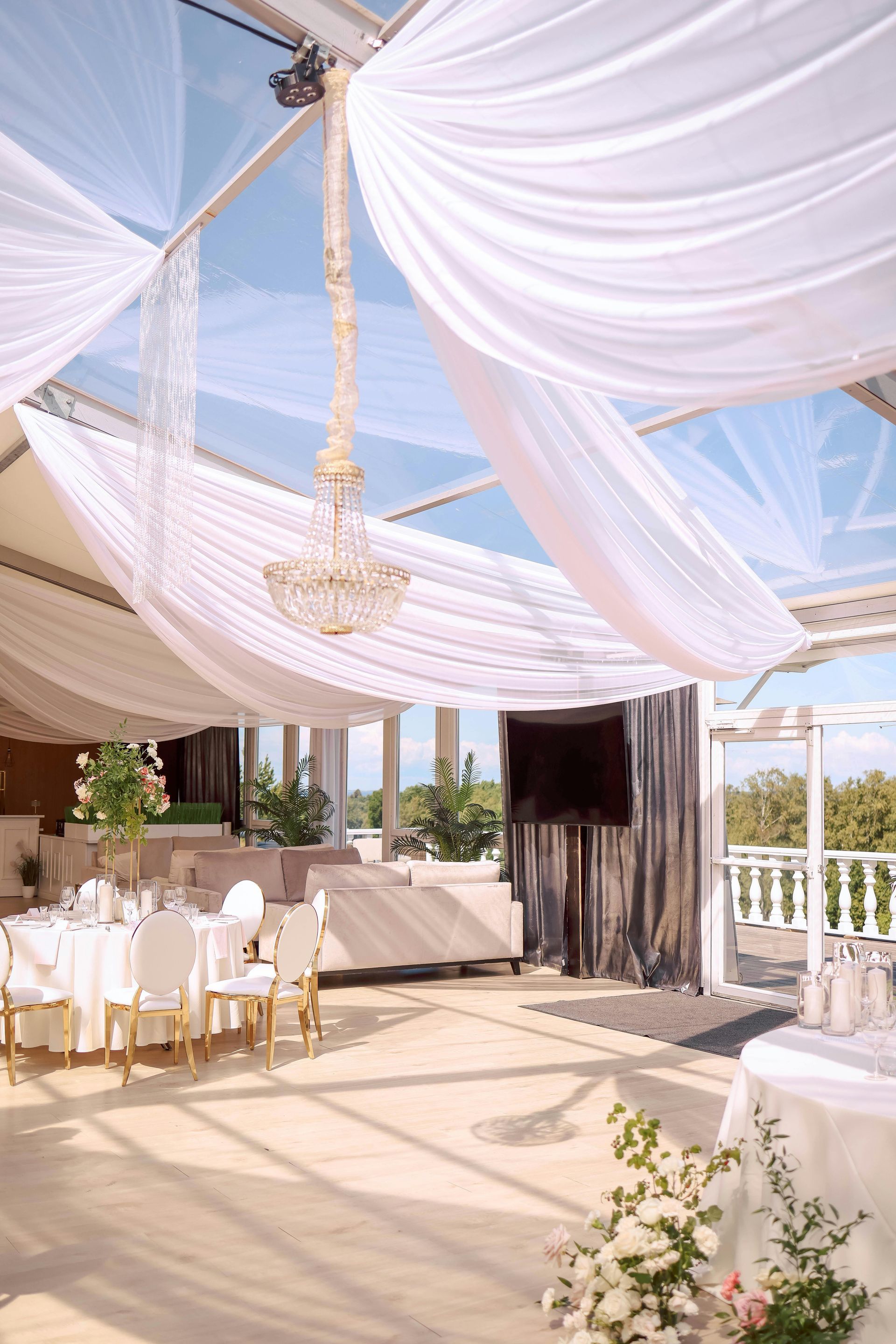 A large room with tables and chairs under a clear tent.