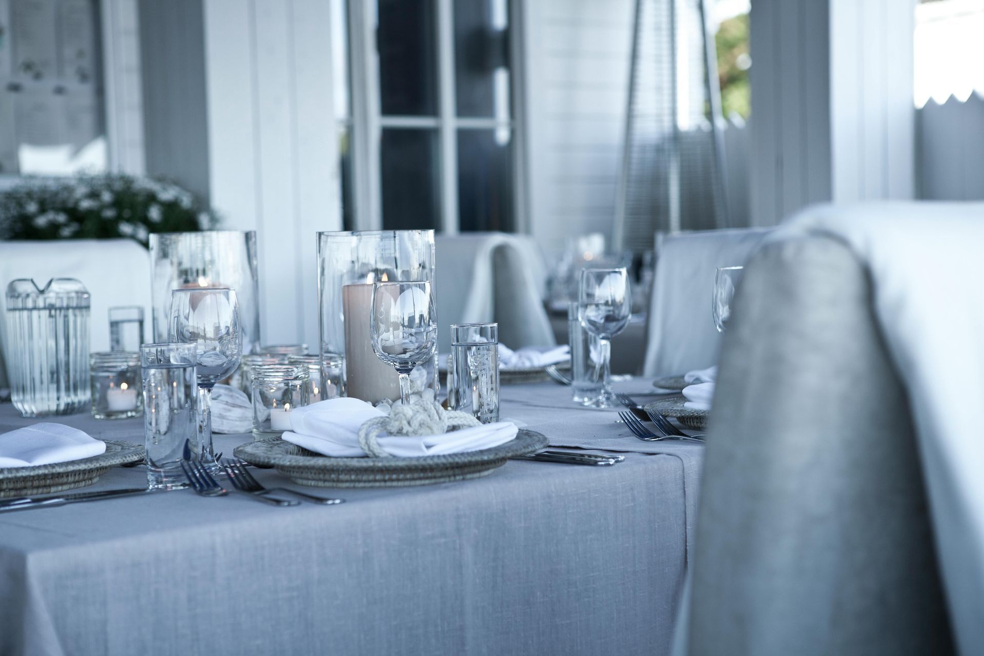 A table with plates , glasses , and candles on it
