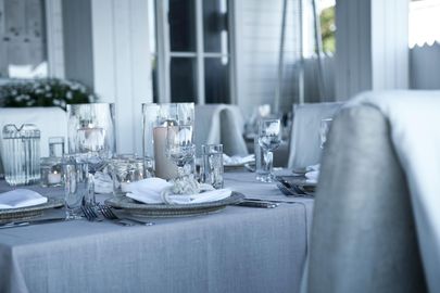 A table with plates , glasses , and candles on it