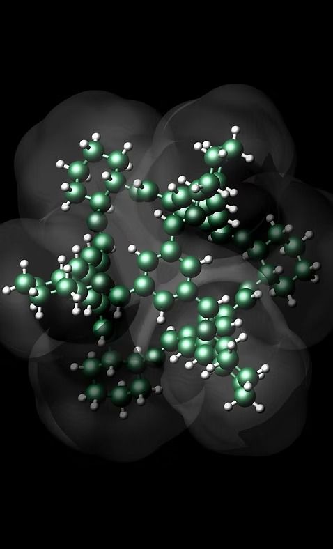 Dark molecular model with green atoms and gray translucent surfaces on a black background