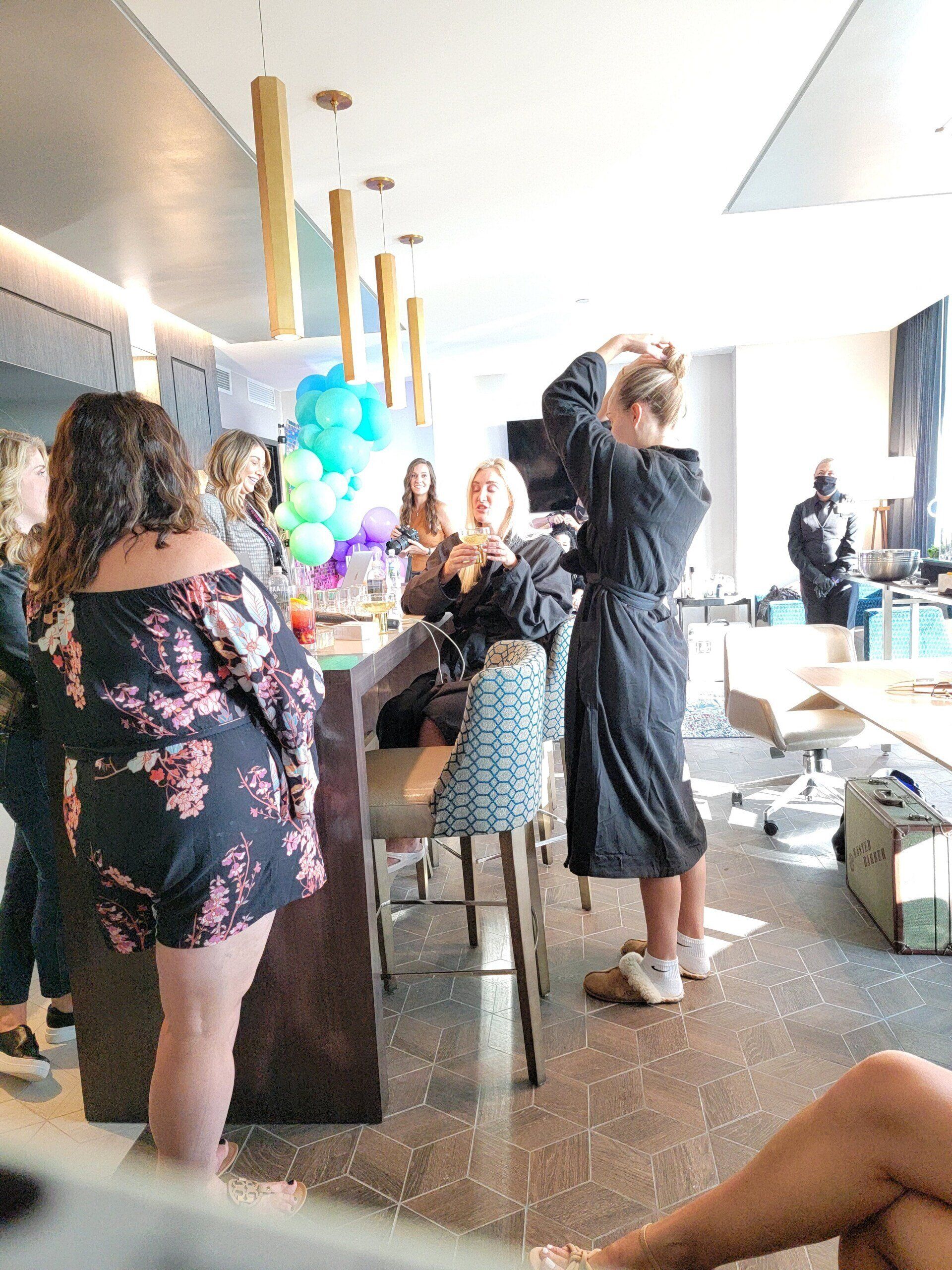 A woman in a robe is standing in a room with other people.