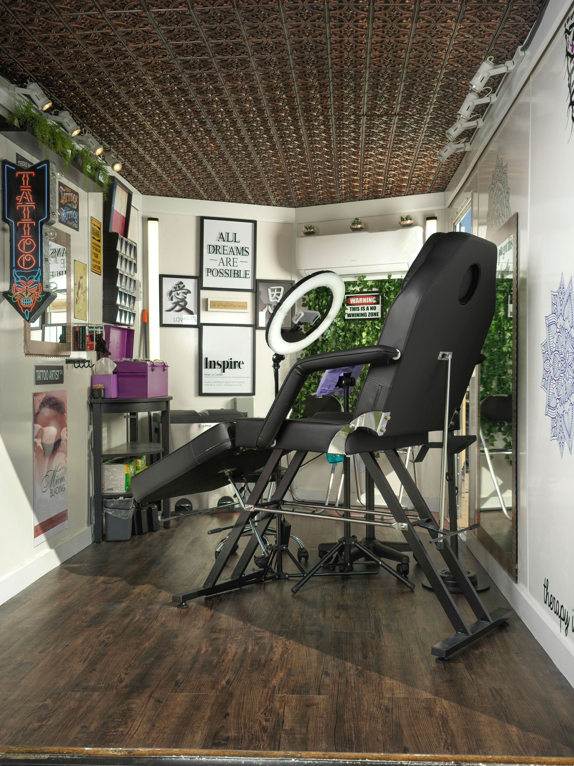 A tattoo studio with a chair and a ring light.