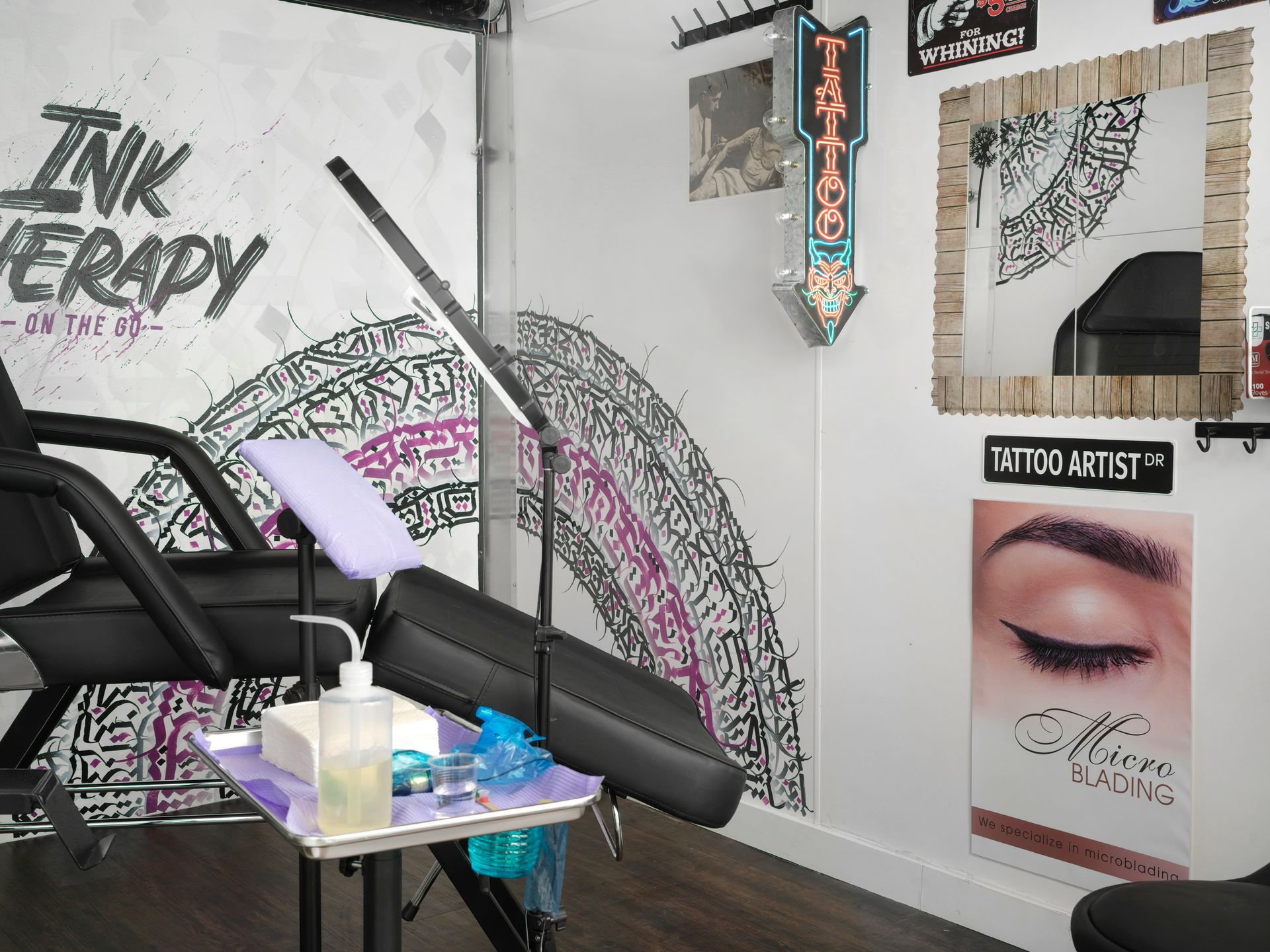 A tattoo studio with a chair and a mirror.