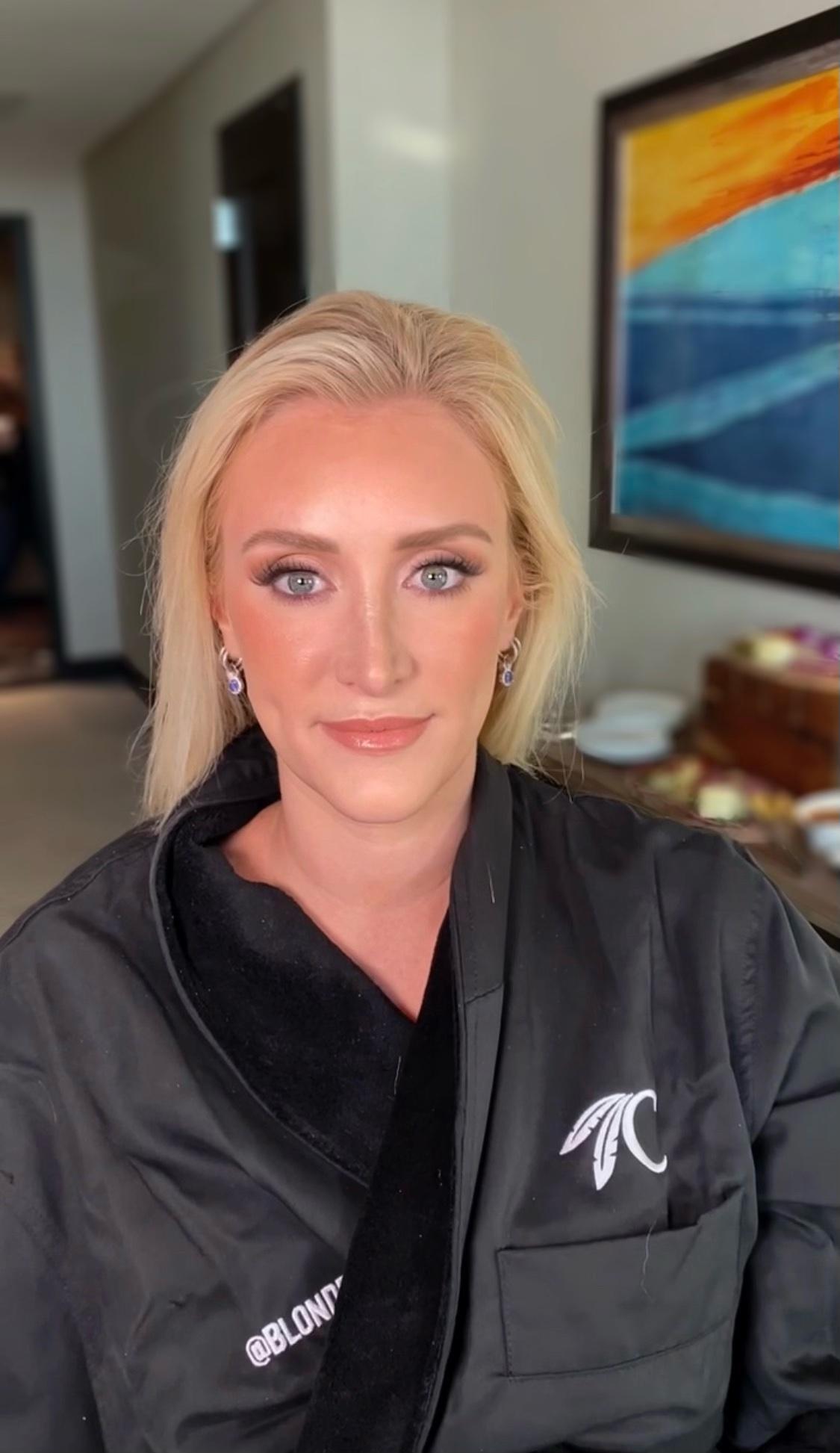 A woman is wearing a black robe with a monogram on the pocket.