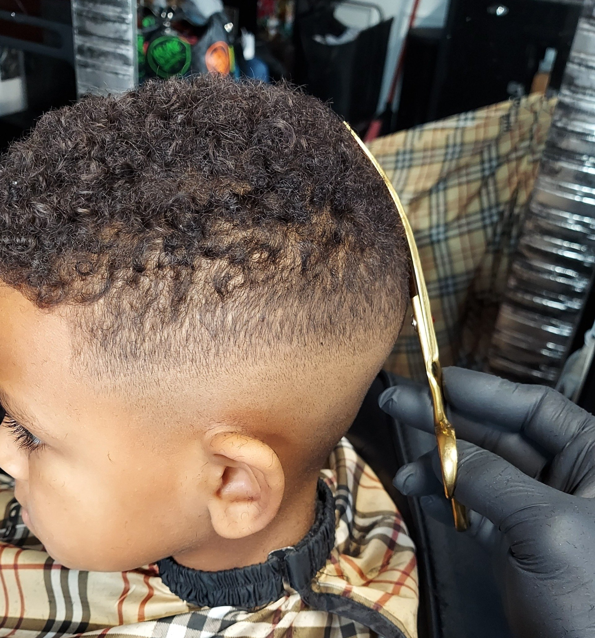 A young boy is getting his hair cut by a barber.