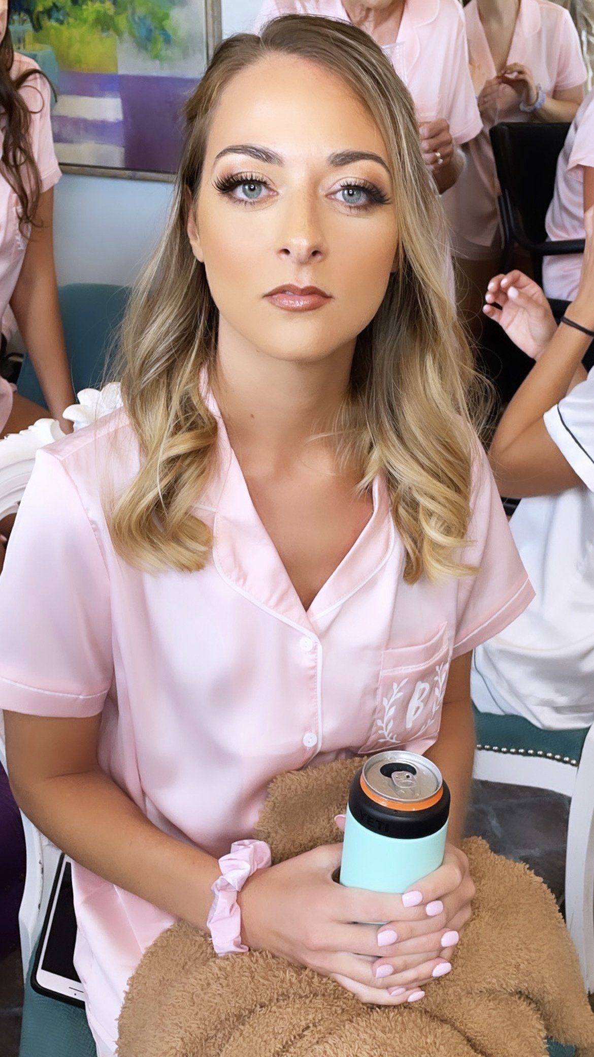 A woman in a pink shirt is holding a can of soda.