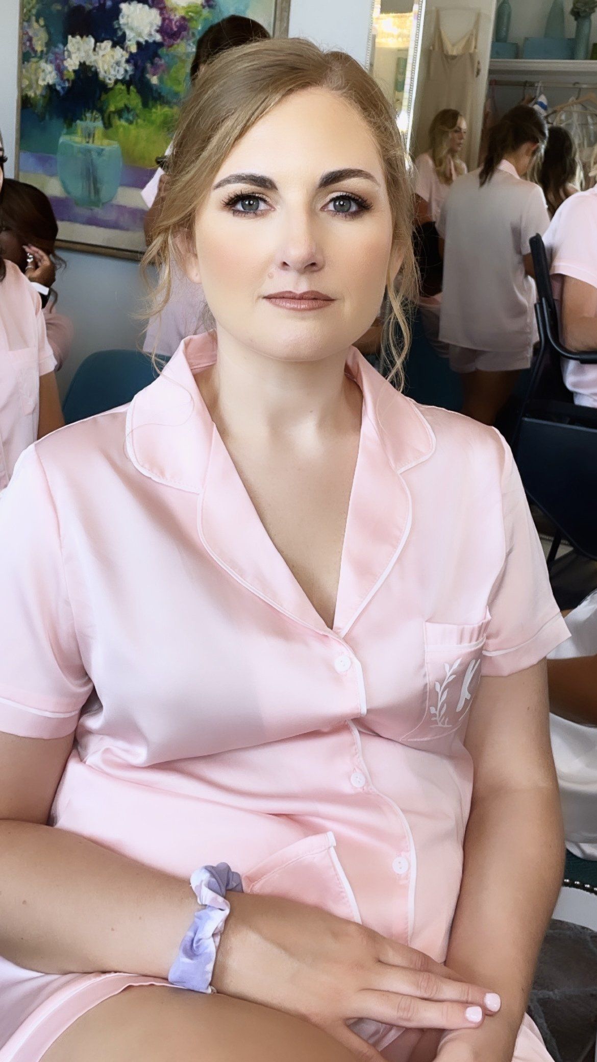 A woman in a pink shirt is sitting in a chair.