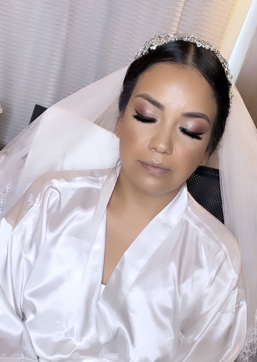 A woman in a white robe and veil is laying in a chair with her eyes closed.