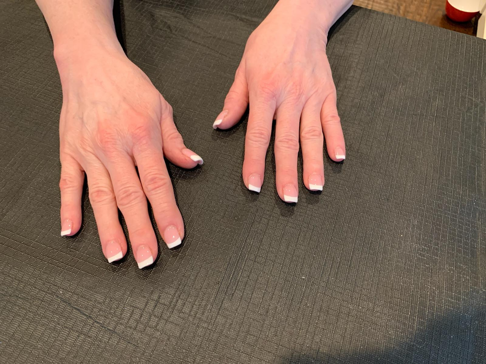 A close up of a woman 's hands with french manicure