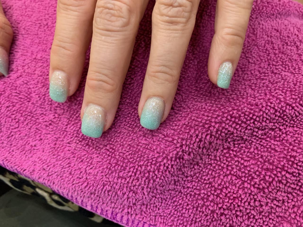 A close up of a woman 's nails on a pink towel.