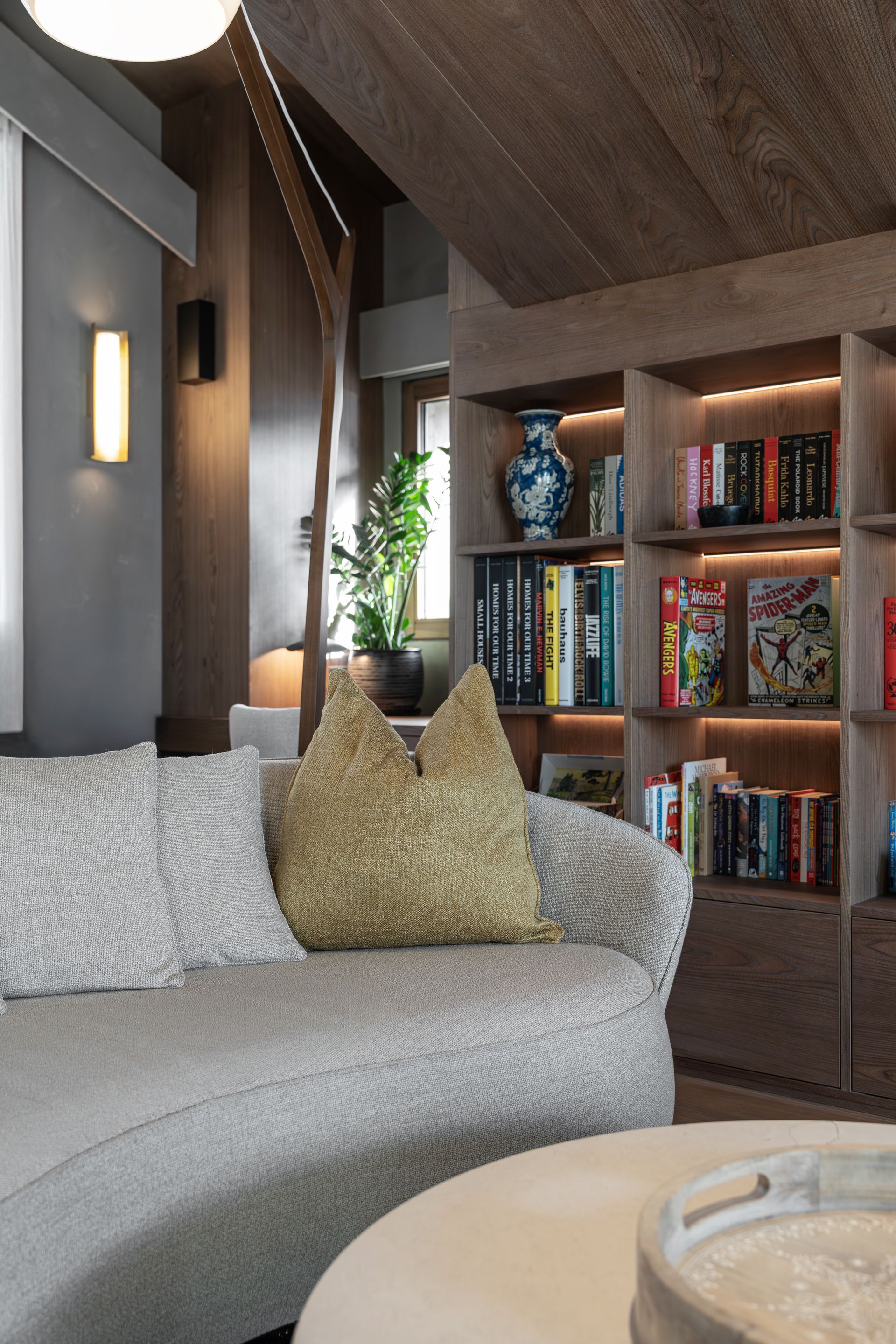 Chalet Escapade A living room with a curved couch and bookshelves