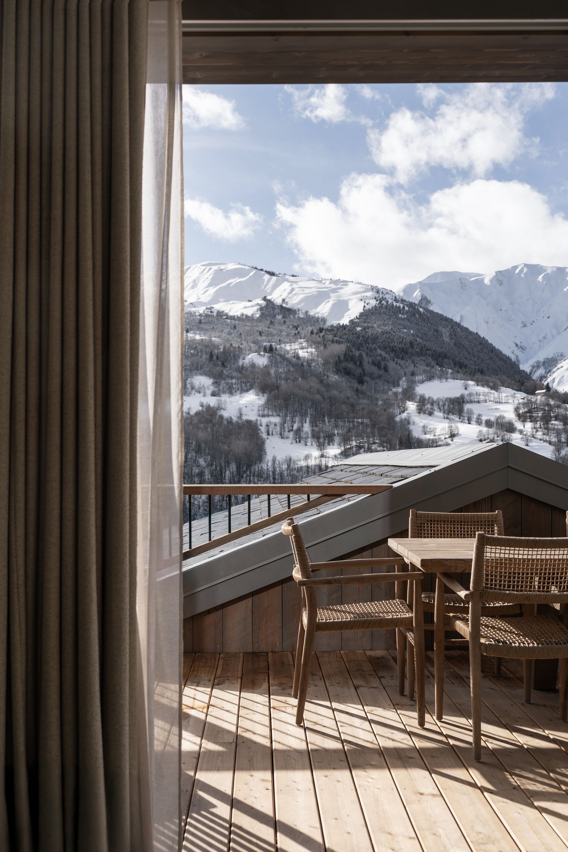 Chalet Escapade A balcony with a view of mountains and a table and chairs.