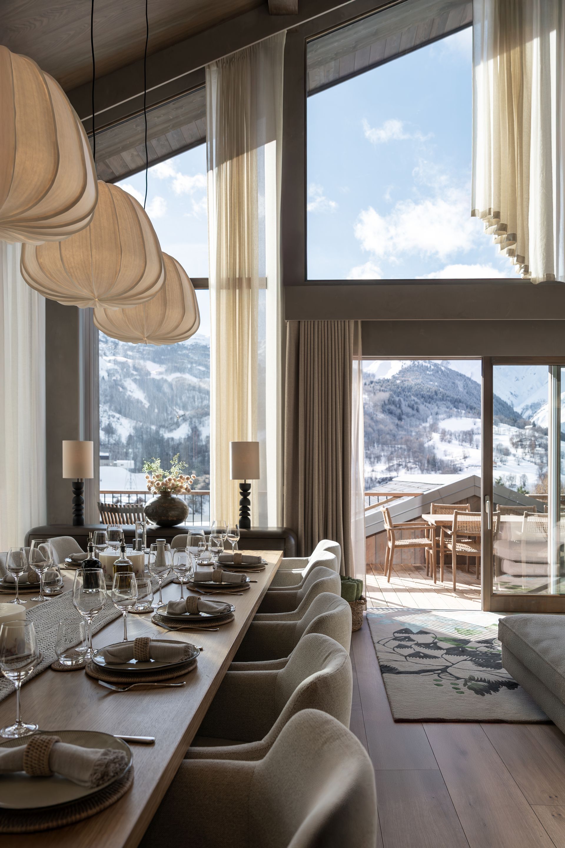 Chalet Escapade A dining room with a long table and chairs and mountains in the background