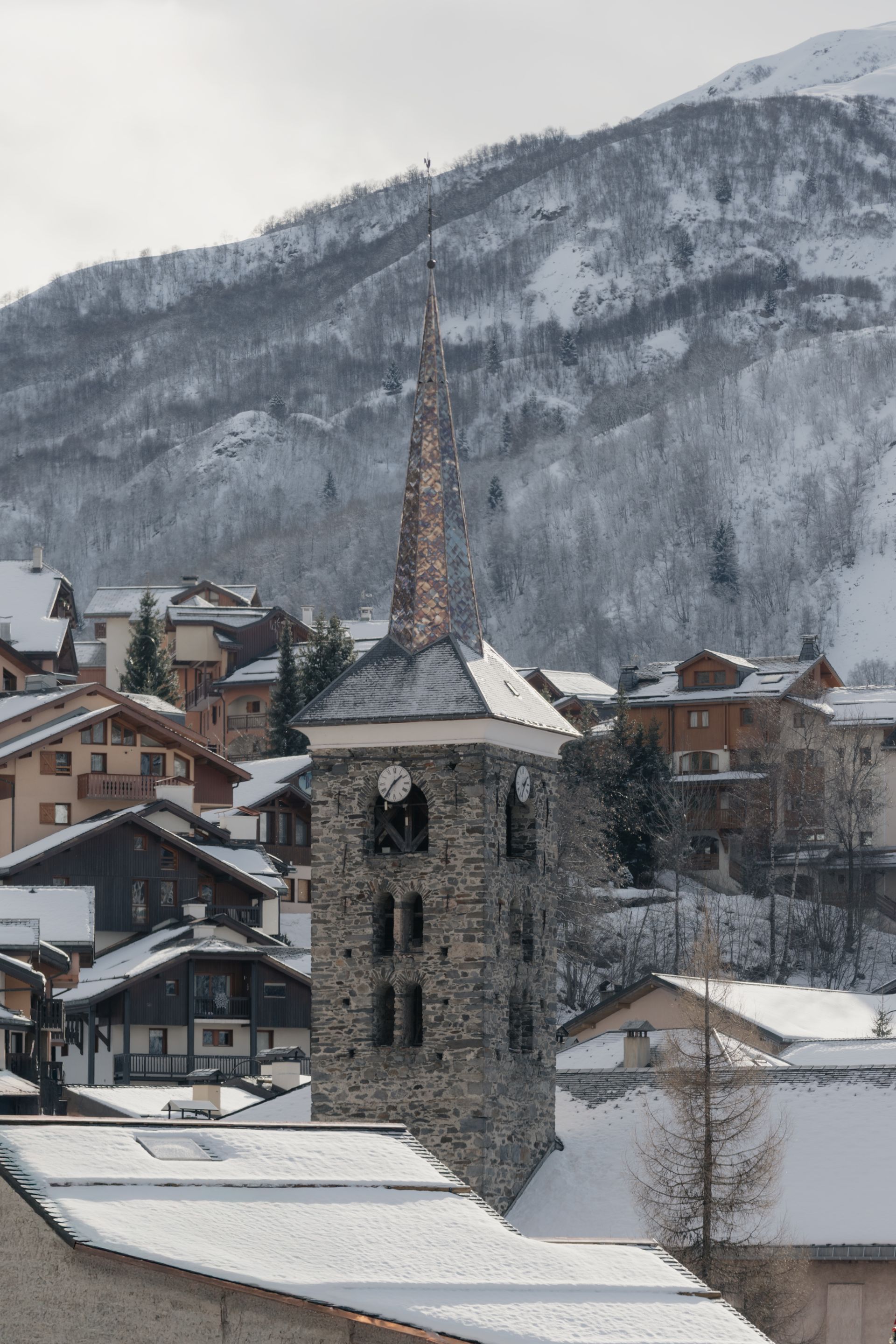 Chalet Escapade A snowy village with a clock tower in the foreground