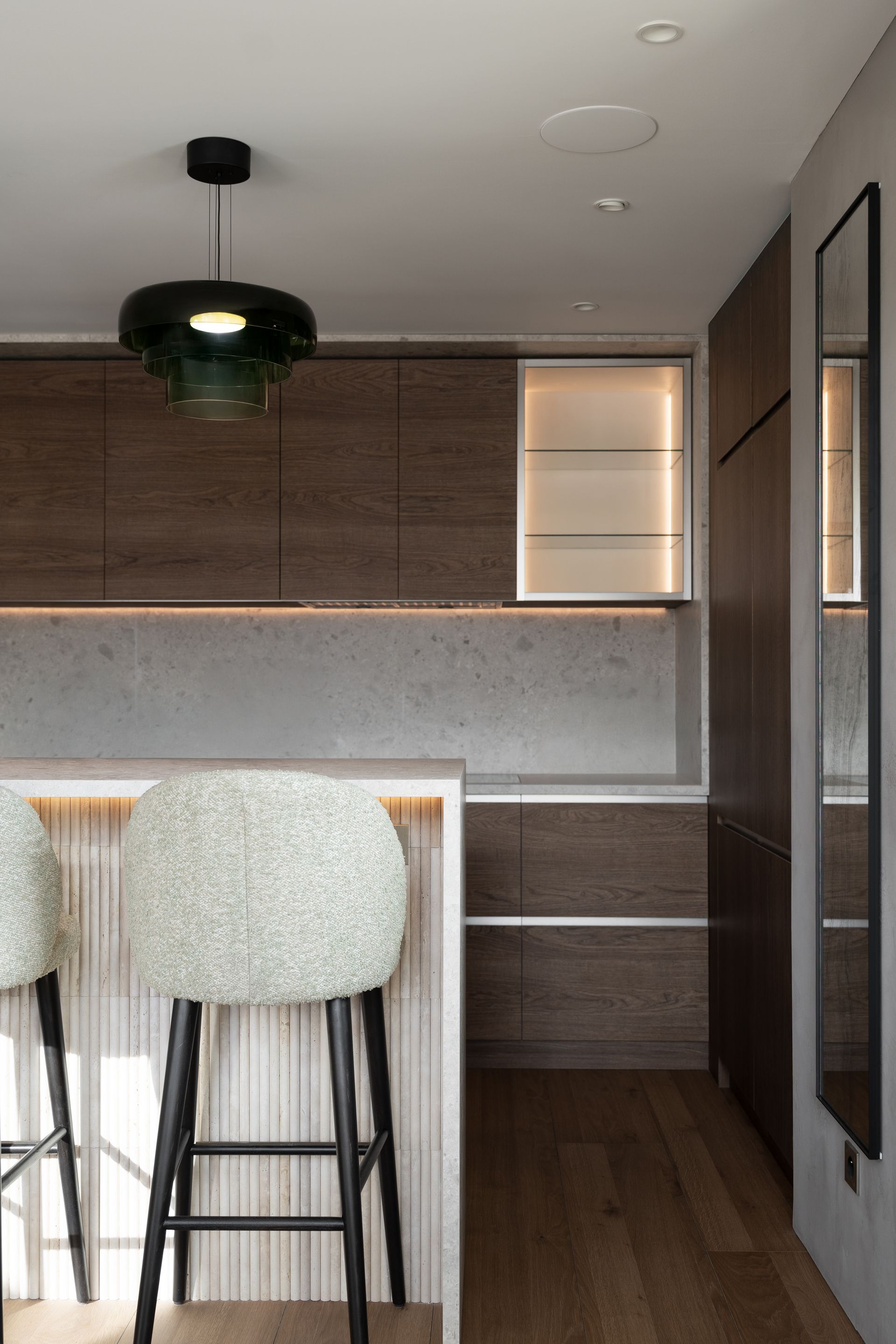 Chalet Escapade A kitchen with a bar and stools and a mirror.