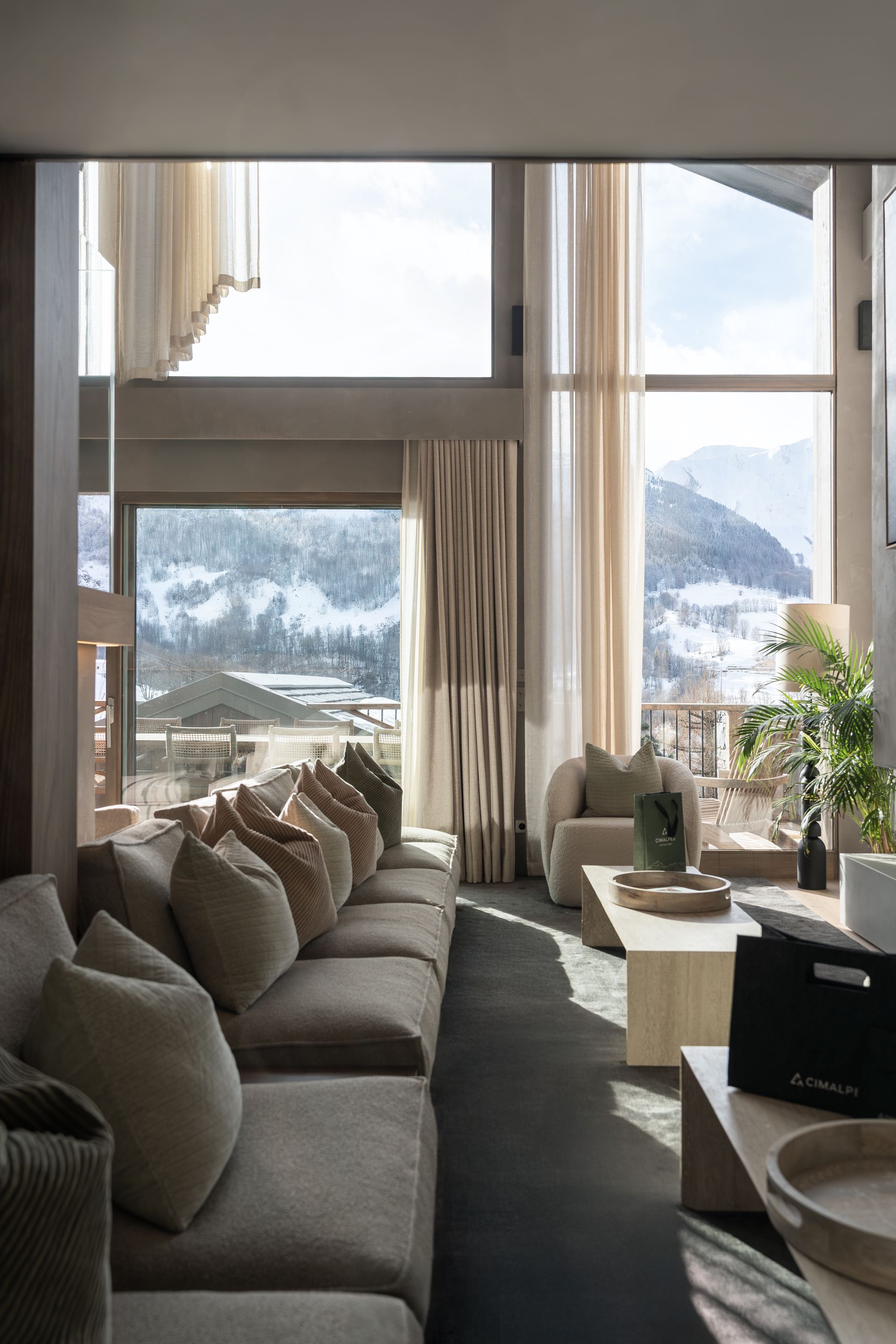 Chalet Escapade A living room with a couch , chair , coffee table and large windows.