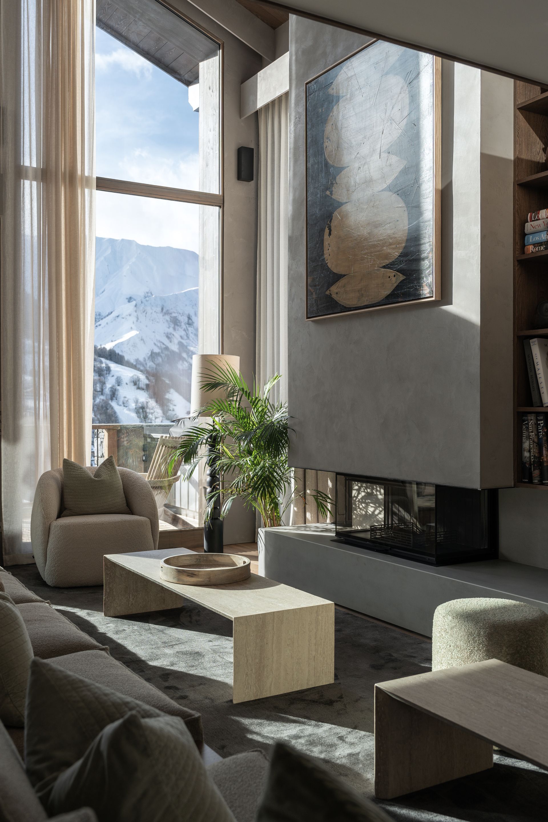 Chalet Escapade A living room with a fireplace , couch , chairs and a large window.