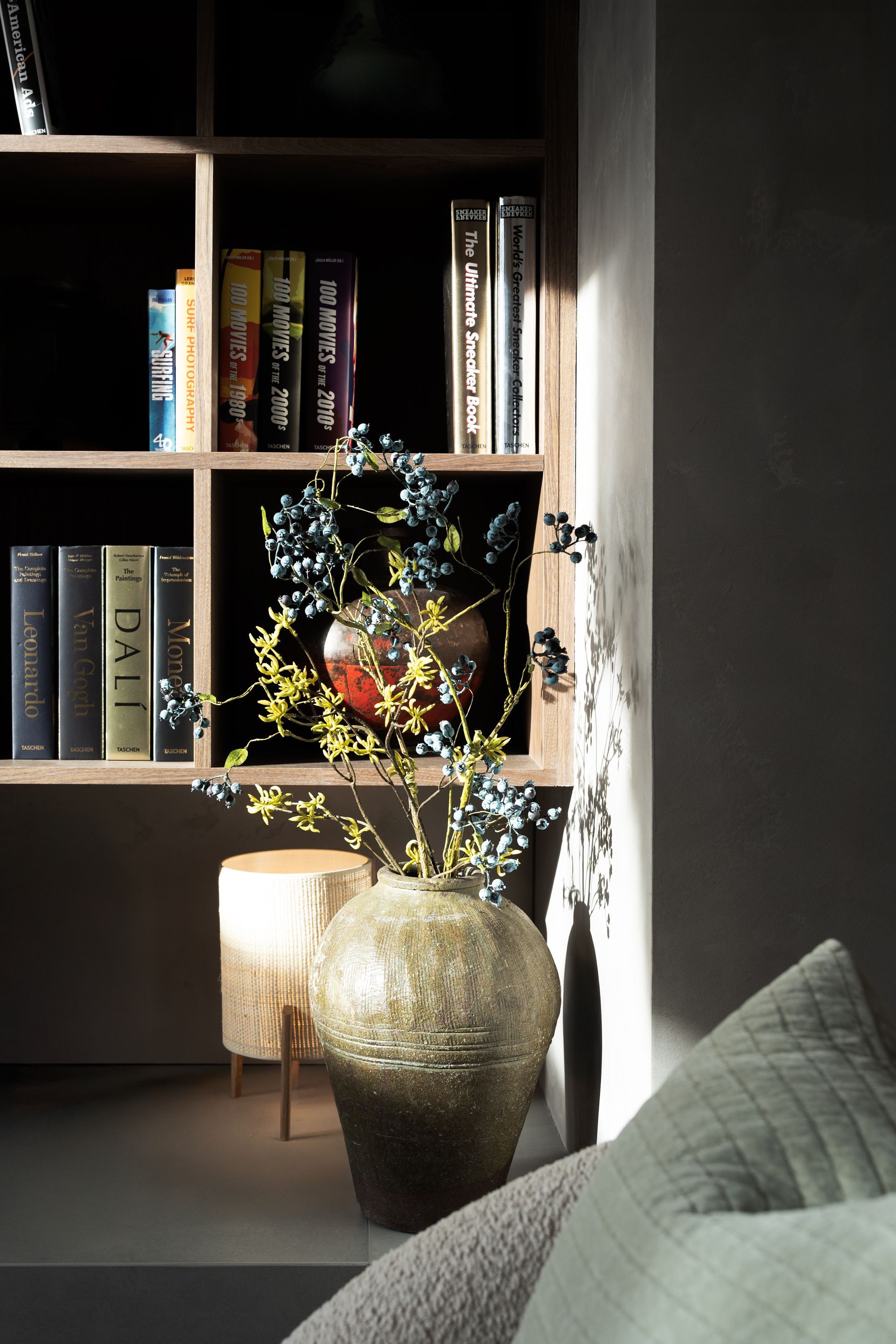 Chalet Escapade A living room with a bookshelf and a vase of flowers