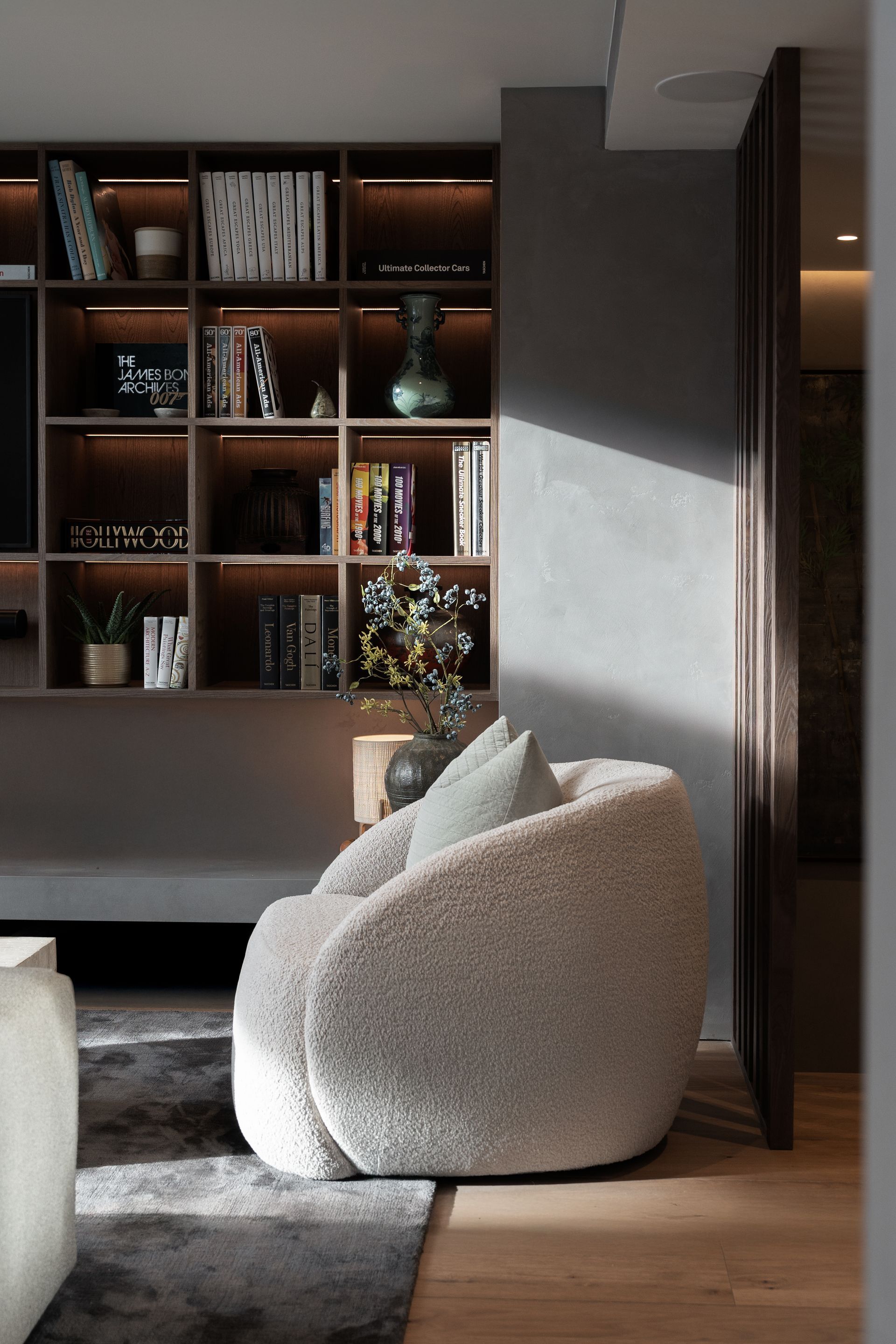 Chalet Escapade A living room with a chair and a bookshelf.