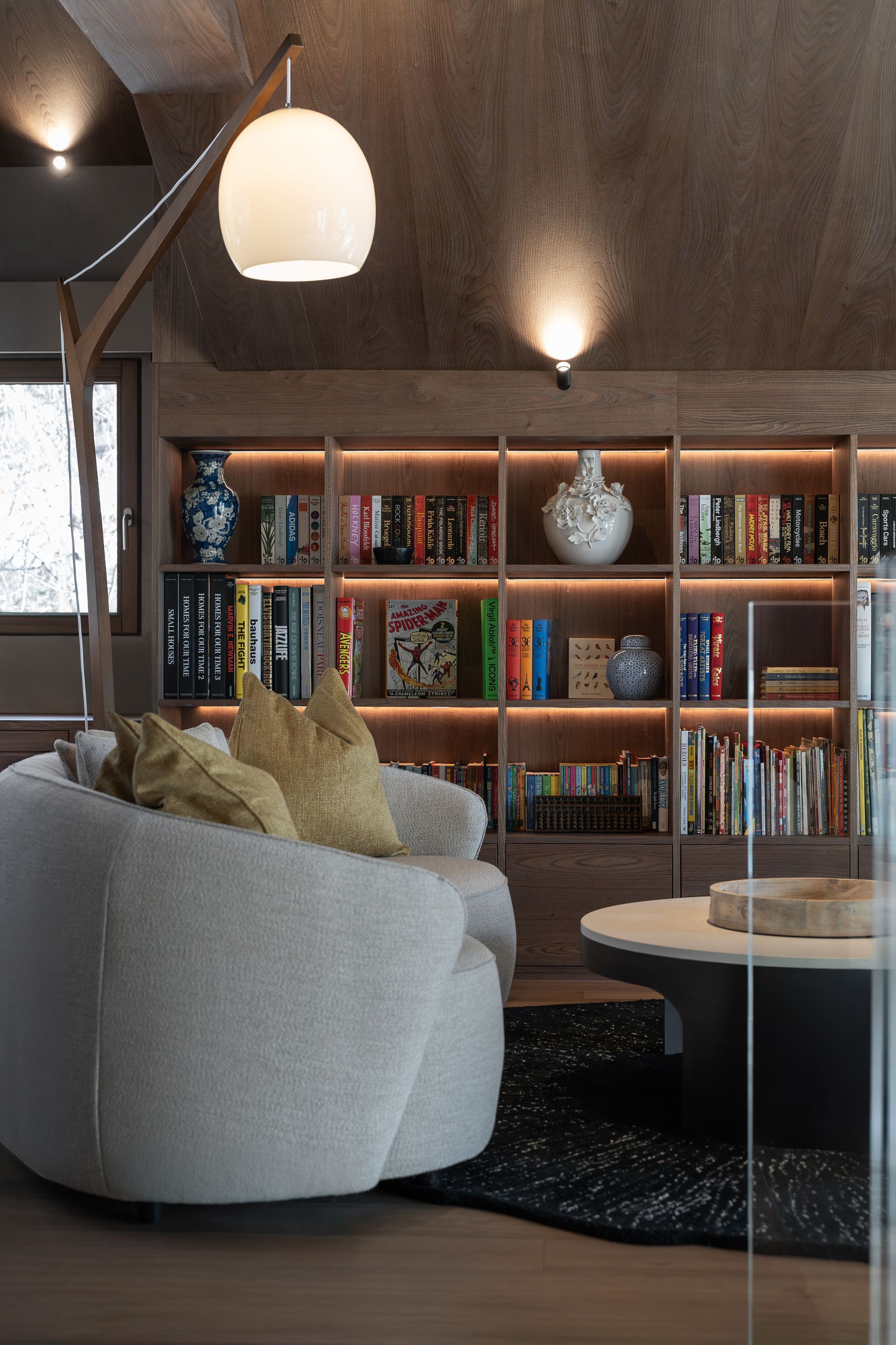 Chalet Escapade A living room with a couch , chair , coffee table and bookshelves.