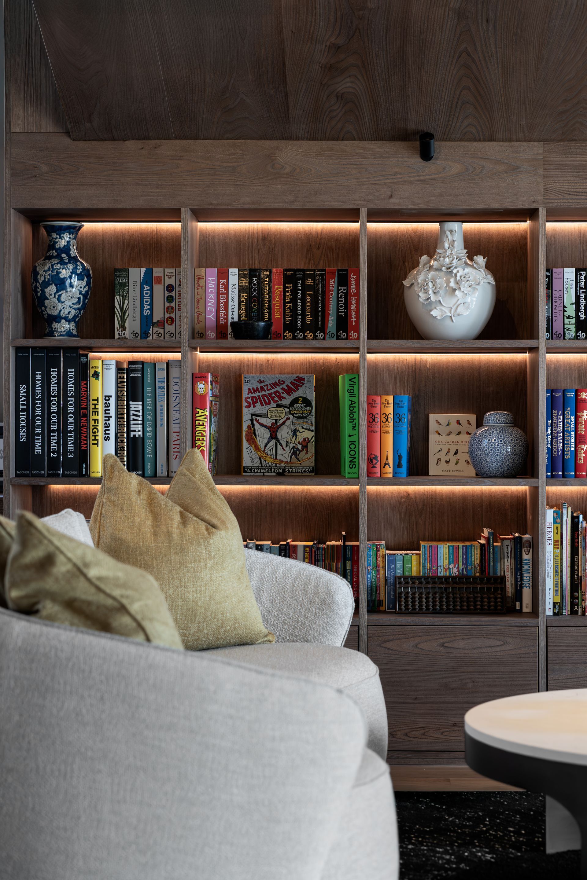 Chalet Escapade A living room with a bookshelf filled with books and vases